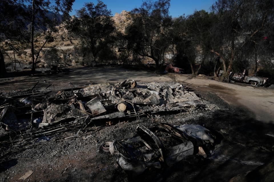 Burned vehicles and a mobile home are left charred by the Highland Fire on Luis Quinonez' property Tuesday in Aguanga.