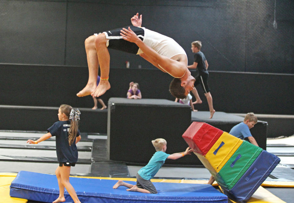 In this Wednesday, July 31, 2013 photo, Jacob Terrell, of Pleasantville, flips as others play at the Get Air Hang Time indoor trampoline park in Orem, Utah. Indoor trampoline parks have cropped up around the country in recent years, offering customers a chance to bounce, flip and jump in wall-to-wall trampolines. The jump gyms offer the kind of rain-or-shine suburban entertainment popular for birthday parties and summer camps. But some doctors and officials say the parks are dangerous and can cause serious injuries. (AP Photo/Rick Bowmer)