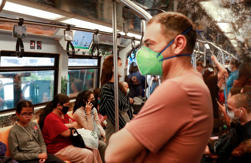 Passengers wear protective masks due to the coronavirus outbreak, in a train in Bangkok