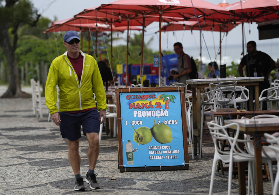 A pedestrian walks past the food and bar kiosk "Nana 2" where four doctors were shot, on the beach in the Barra de Tijuca neighborhood of Rio de Janeiro, Brazil, Thursday, Oct. 5, 2023. Three of the doctors died in the overnight shooting. (AP Photo/Silvia Izquierdo)