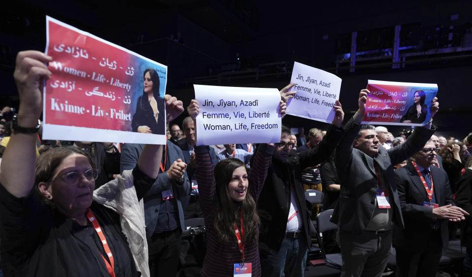 People hold protest poster during a congress of the Party of European Socialists (PES) in Berlin, Germany, Saturday, Oct. 15, 2022 to protest against the government in Iran in memory of Mahsa Amini, a young Iranian woman who died after being arrested in Tehran by Iran's 'morality police'. (AP Photo/Michael Sohn)
