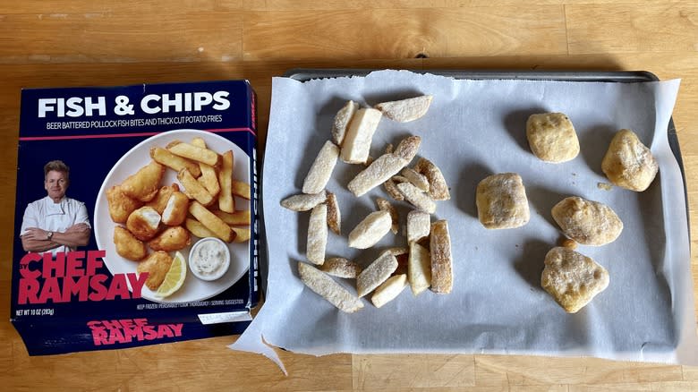 Frozen fish and chips on baking tray next to box