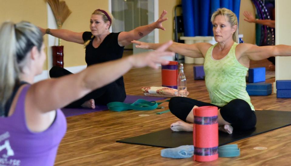 Clients participate in a yoga class led by Jenna Lomazzo, at left closest to camera, at Thee House of Yoga in Indialantic.