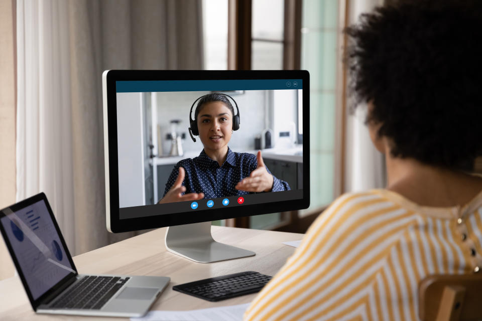 African American customer woman talking to support service employee, operator on video call. Female business coworkers discussing project marketing report on distance virtual chat at computer monitor