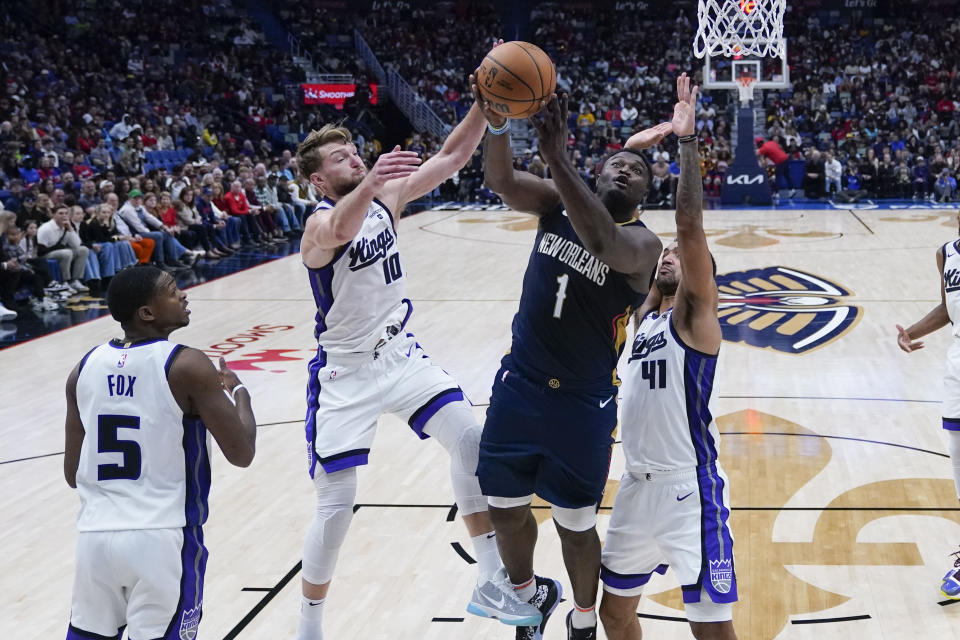 New Orleans Pelicans forward Zion Williamson (1) drives to the basket against Sacramento Kings forward Domantas Sabonis (10) and forward Trey Lyles (41) in the second half of an NBA basketball game in New Orleans, Wednesday, Nov. 22, 2023. The Pelicans won 117-112. (AP Photo/Gerald Herbert)