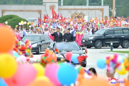 North Korean leader Kim Jong Un welcomes Chinese President Xi Jinping at the Pyongyang International Airport in Pyongyang