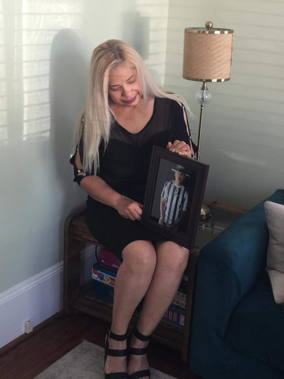 Maria De Los Angeles Pena holds a photo of her son Rudy, who was crushed in the Astroworld tragedy on 5 November 2021 (Courtesy of Pena family)