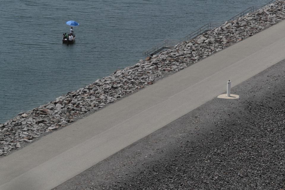 An empty road next to a lake.