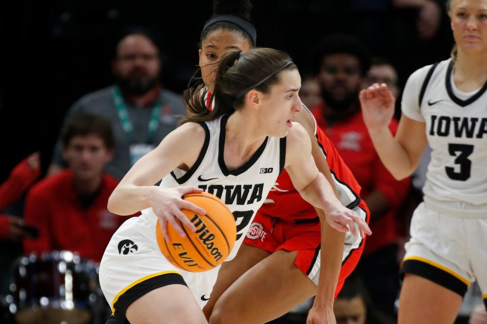 Iowa's Caitlin Clark dribbles around Ohio State's Taylor Thierry.