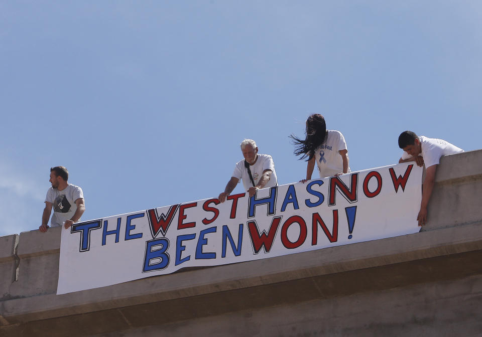 Supporters of the Bundy family hang a sign on the I-15 highway just outside of Bunkerville, Nev. after the Bureau of Land Management agreed to release the impounded cattle on April 12, 2014. (AP Photo/Las Vegas Review-Journal, Jason Bean)