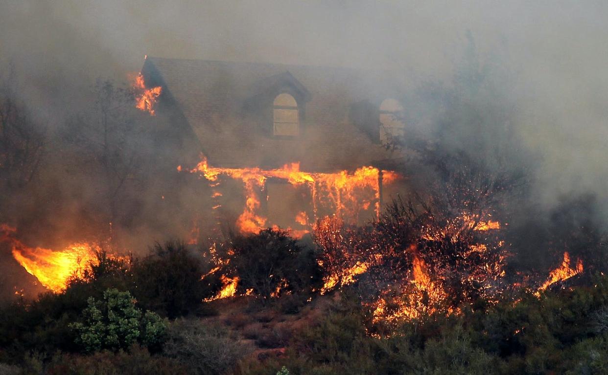 <span class="caption">How homes are built and landscaped affects their ability to withstand a wildfire.</span> <span class="attribution"><a class="link " href="https://www.gettyimages.com/detail/news-photo/house-burns-after-being-overcome-by-flames-from-the-rocky-news-photo/482572190" rel="nofollow noopener" target="_blank" data-ylk="slk:Justin Sullivan/Getty Images;elm:context_link;itc:0;sec:content-canvas">Justin Sullivan/Getty Images</a></span>