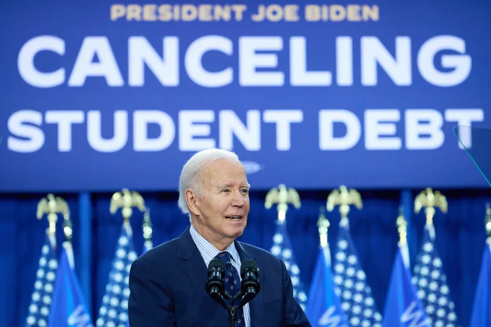  Joe Biden speaks in front of a sign that reads "President Joe Biden Cancelling Student Debt" (Daniel Steinle / Bloomberg via Getty Images file)