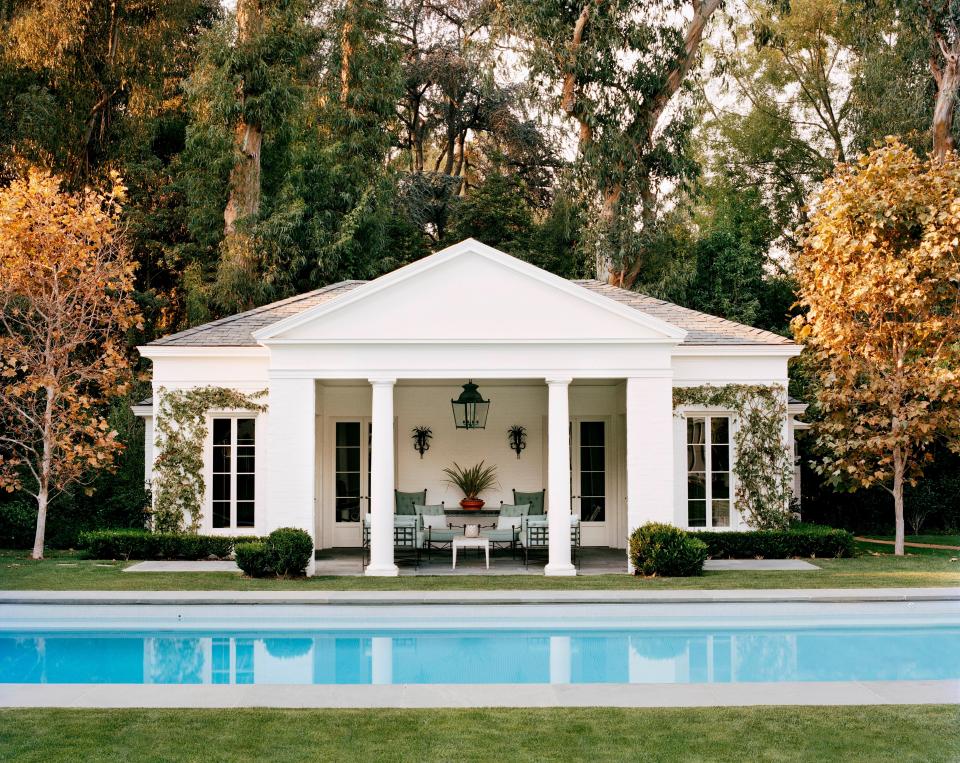 The pedimented Doric temple front of the poolhouse was inspired by the classical follies of 18th-century English gardens. The furniture is by Janus et Cie and the lantern is by Soane Britain.