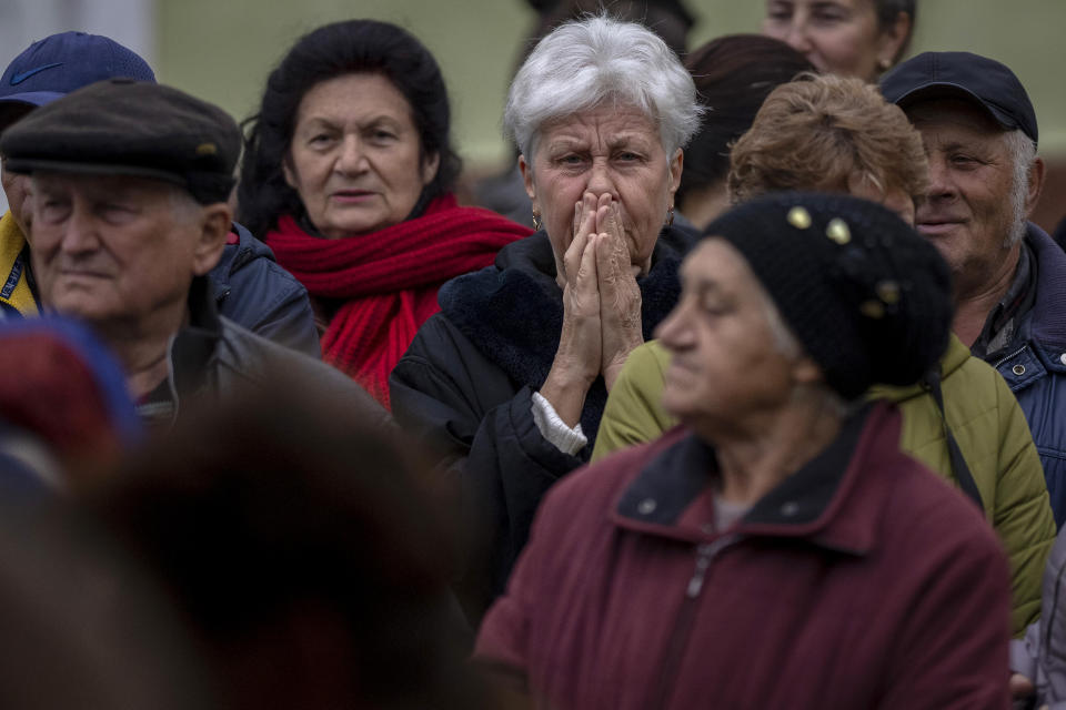 People queue to receive a daily ration of bread in a school in Mykolaiv, Tuesday, Oct. 25, 2022. Mykolaiv residents pick up bread from the only food distribution point in Varvarivka, a Mykolaiv district where thousands of people live. One person is allowed to receive free bread just once in three days. (AP Photo/Emilio Morenatti)