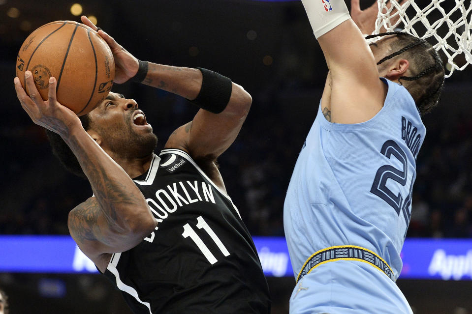 Brooklyn Nets guard Kyrie Irving (11) shoots against Memphis Grizzlies forward Dillon Brooks (24) during the first half of an NBA basketball game Wednesday, March 23, 2022, in Memphis, Tenn. (AP Photo/Brandon Dill)