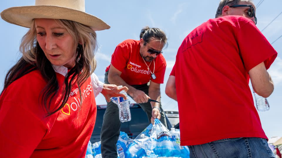 Volunteers organize water bottles for homeless people in Phoenix on Friday as the city continued to bake.  i - Brandon Bell/Getty Images