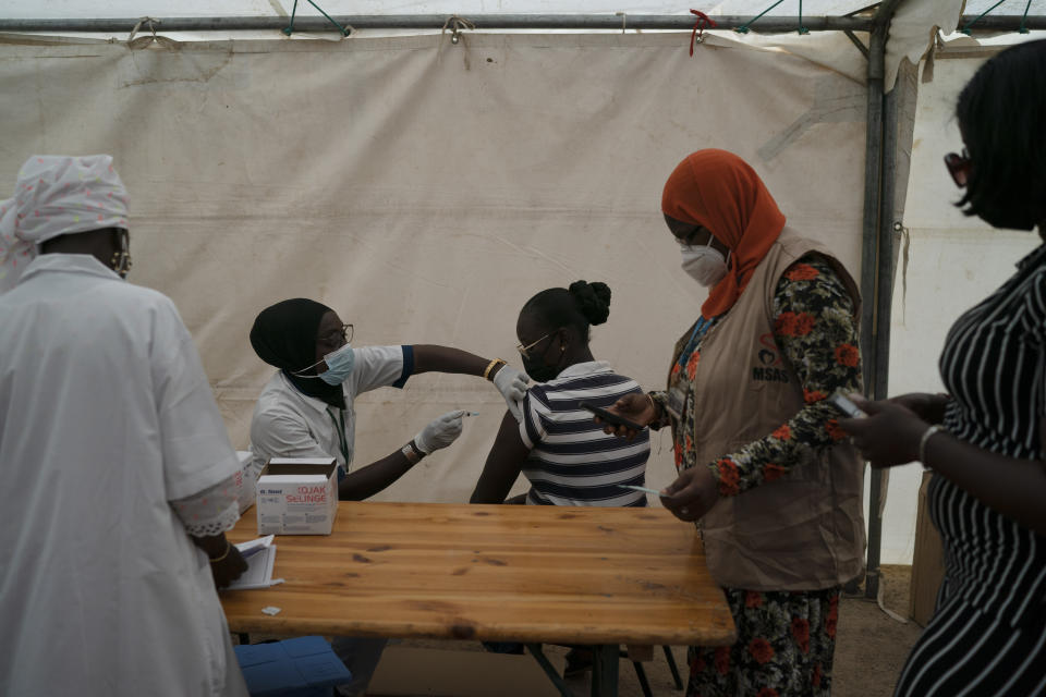 FILE- In this Wednesday, July 28, 2021 file photo, A health worker administers a dose of Janssen COVID-19 vaccine at Leopold Sedar Senghor stadium in Dakar, Senegal. Thousands of new coronavirus cases have been reported in West Africa in recent weeks amid low vaccination rates and the spread of the delta variant. (AP Photo/Leo Correa, File)