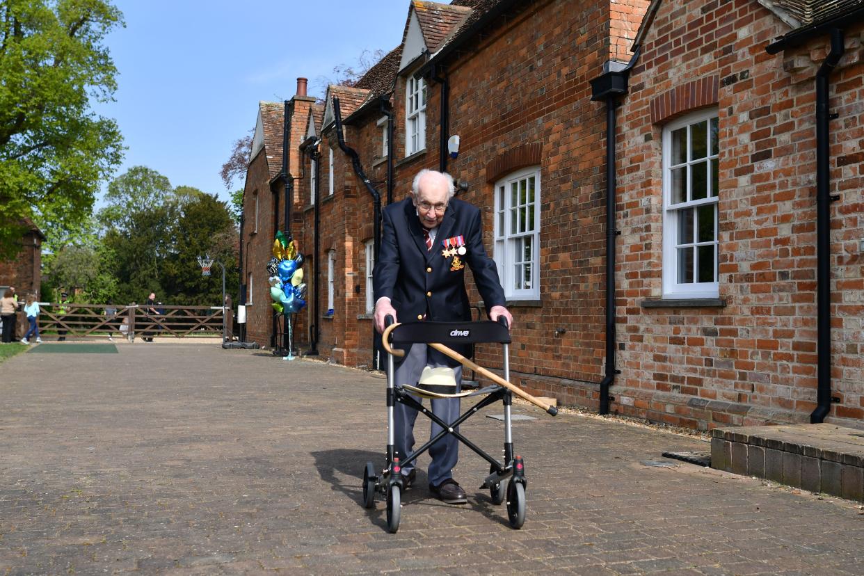 British World War II veteran Captain Tom Moore, 99, poses with his walking frame doing a lap of his garden in the village of Marston Moretaine, 50 miles north of London, on April 16, 2020. - A 99-year-old British World War II veteran Captain Tom Moore on April 16 completed 100 laps of his garden in a fundraising challenge for healthcare staff that has "captured the heart of the nation", raising more than £13 million ($16.2 million, 14.9 million euros). "Incredible and now words fail me," Captain Moore said, after finishing the laps of his 25-metre (82-foot) garden with his walking frame. (Photo by Justin TALLIS / AFP) (Photo by JUSTIN TALLIS/AFP via Getty Images)