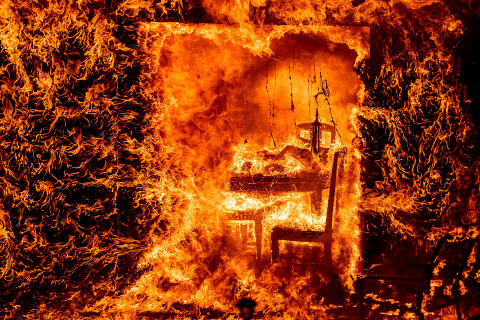 Flames engulf a chair inside a burning home as the Oak Fire burns in Mariposa County, Calif., on July 23.<span class="copyright">Noah Berger—AP</span>