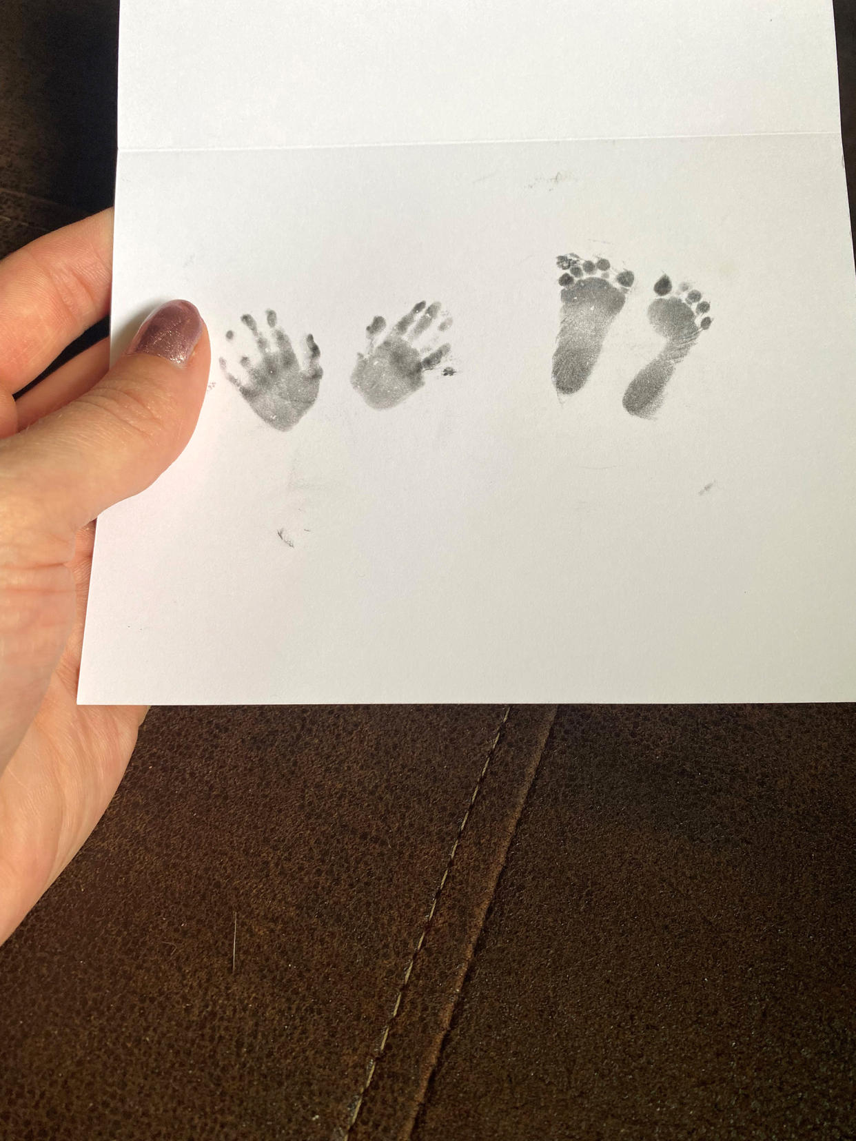 Melissa Janssen holds a paper card with her child's hand and foot prints. (Courtesy Melissa Janssen)
