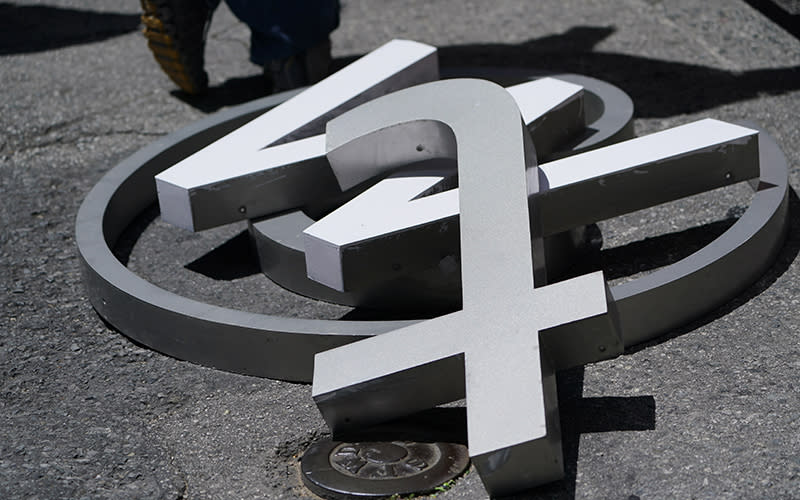 Metal letters consisting of the "T," "W," and @ symbol from a sign on the Twitter headquarters are seen in a pile