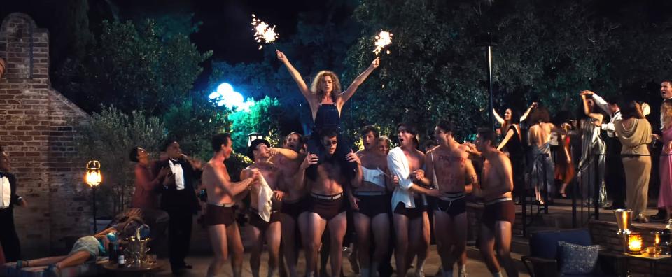 Nellie on the shoulders of a man, holding sparklers at another party