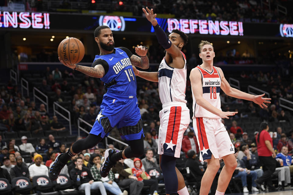 Orlando Magic guard D.J. Augustin (14) looks to pass the ball next to Washington Wizards guard Troy Brown Jr., center, and center Anzejs Pasecniks (18) during the first half of an NBA basketball game Wednesday, Jan. 1, 2020, in Washington. (AP Photo/Nick Wass)