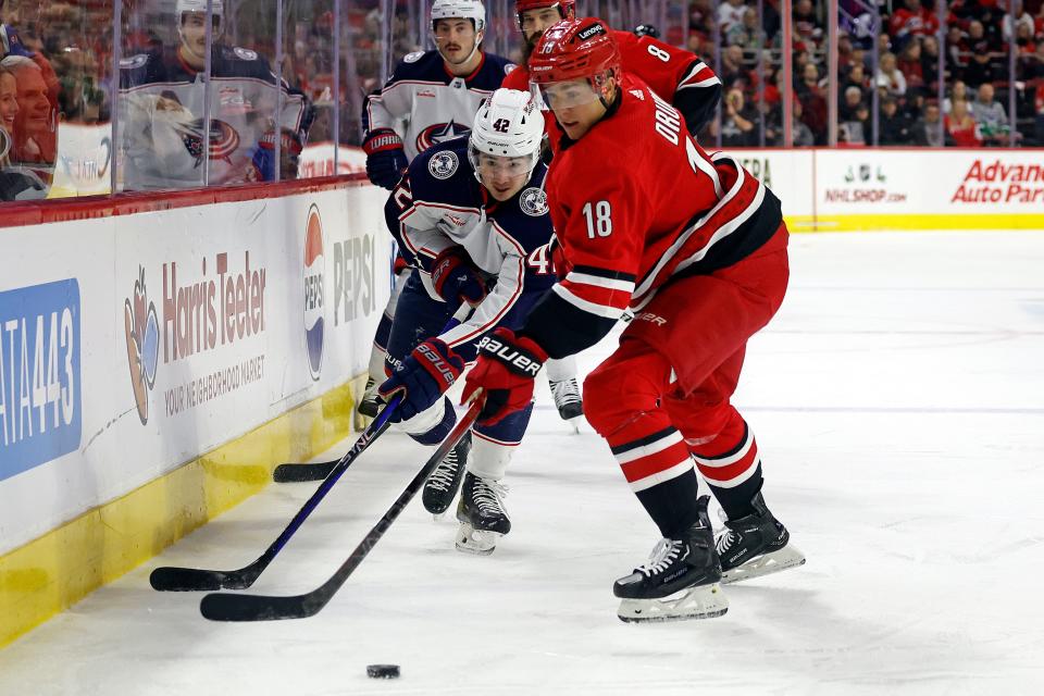 Carolina Hurricanes' Jack Drury (18) controls the puck in front of Columbus Blue Jackets' Alexandre Texier (42) during the first period of an NHL hockey game in Raleigh, N.C., Sunday, Nov. 26, 2023. (AP Photo/Karl B DeBlaker)