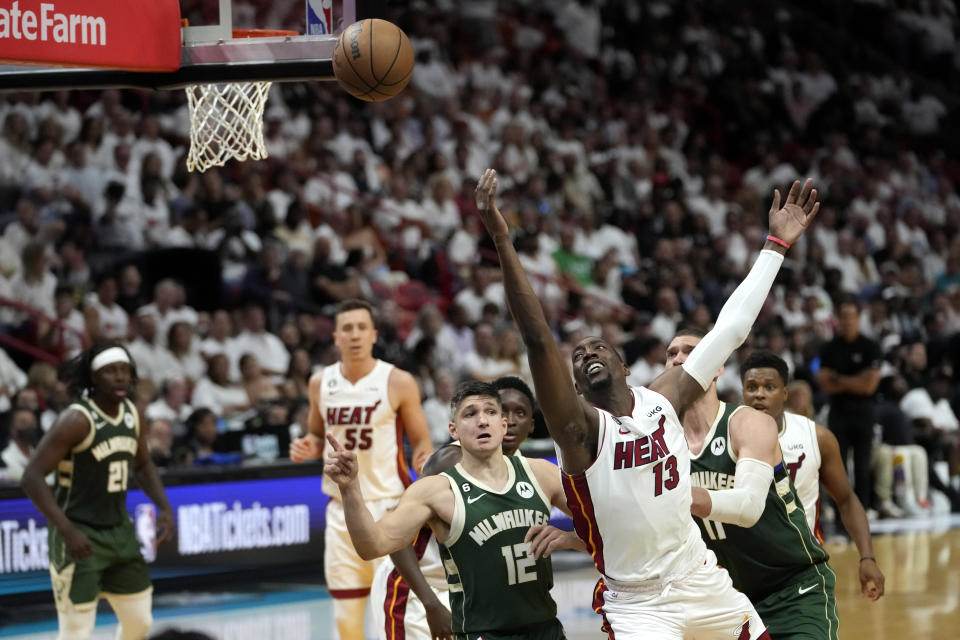 Miami Heat center Bam Adebayo (13) goes for a loose ball against Milwaukee Bucks guard Grayson Allen (12) during the second half of Game 3 in a first-round NBA basketball playoff series, Saturday, April 22, 2023, in Miami. (AP Photo/Lynne Sladky)