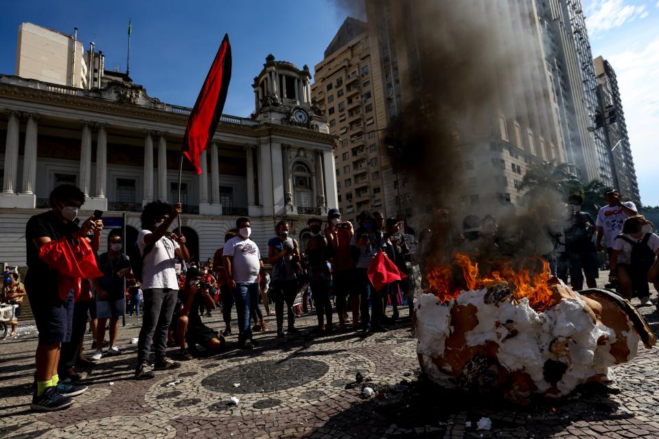 Demonstrators set fire a head prop depicting Brazilian President Jair Bolsonaro during a protest on May 29, 2021 in Rio de Janeiro, Brazil. (Getty Images)