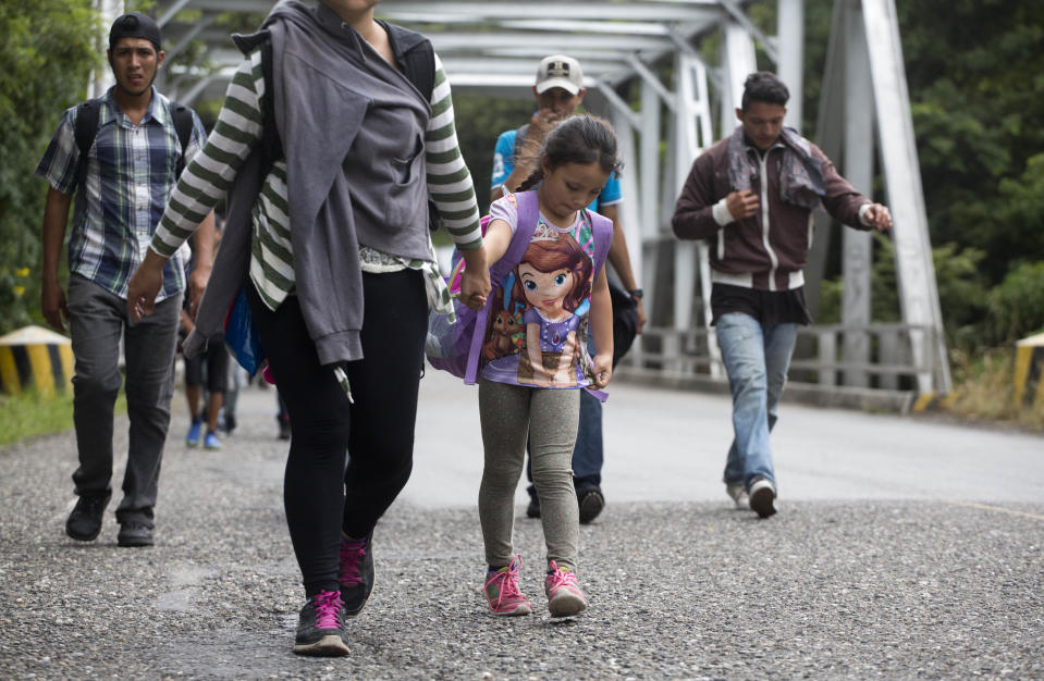 Honduran migrants walk in a group toward the U.S., as they make their way through Chiquimula, Guatemala, Tuesday, Oct. 16, 2018. U.S. President Donald Trump threatened on Tuesday to cut aid to Honduras if it doesn't stop the impromptu caravan of migrants, but it remains unclear if governments in the region can summon the political will to physically halt the determined border-crossers. (AP Photo/Moises Castillo)