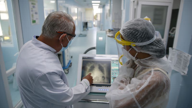 Dr. Shemsedin Dreshaj, left, head of the ICU unit, looks at the X-ray of the lungs of a patient with COVID-19 in the Clinic for Infectious Diseases in Pristina, Kosovo, Monday, Sept. 21, 2020. WHO is investigating more diseases, such as disease X, that could cause another pandemic.