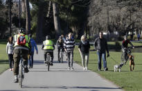 Residents exercise at Hagley Park in Christchurch, New Zealand, Sunday, Aug. 9, 2020. New Zealand on Sunday marked 100 days since it stamped out the spread of the coronavirus, a rare bright spot in a world that continues to be ravaged by the disease. (AP Photo/Mark Baker)