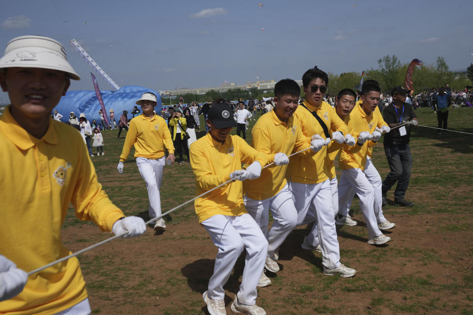 Participants fly a kite during the 41st International Kite Festival in Weifang, Shandong Province of China, Saturday, April 20, 2024. (AP Photo/Tatan Syuflana)