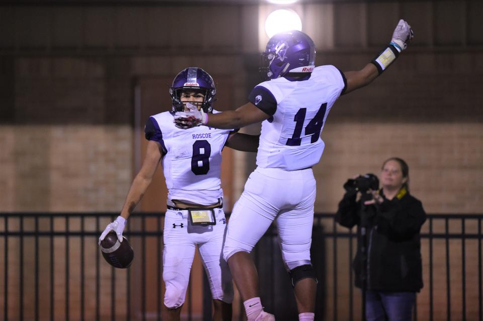 Roscoe's Antonio Aguayo (8) and Ivan McCann (14) celebrate a touchdown during Thursday's Region II-2A Division II bi-district playoff against Quanah at Post on Nov. 11, 2021. The Plowboys pulled away for the 38-16 victory.