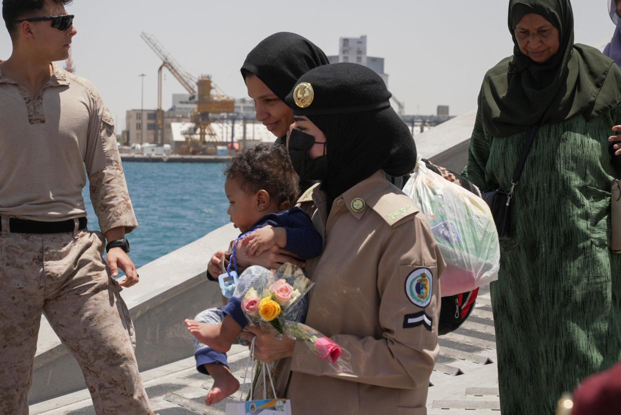 A Saudi Royal Navy female officer helps a woman disembark from the U.S. Navy fast transport ship (REUTERS)