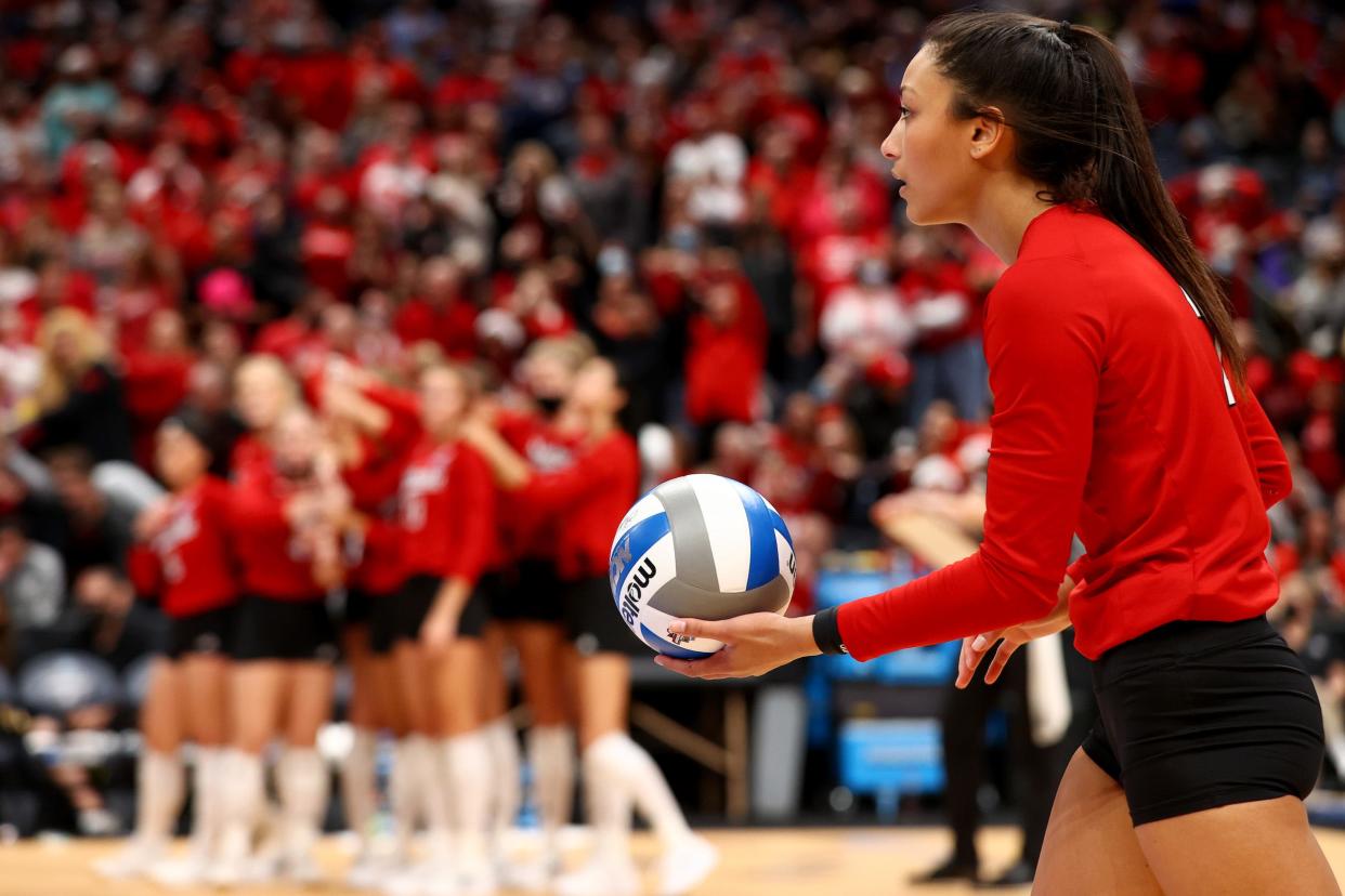 A Nebraska volleyball player prepares to serve.