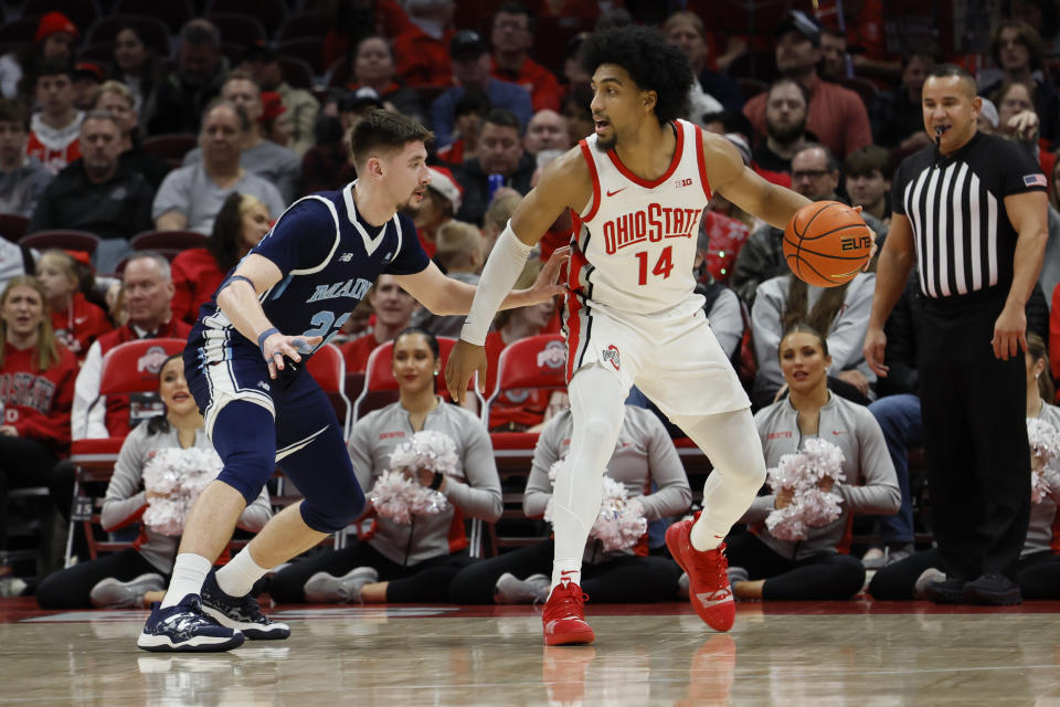 Ohio State's Justice Sueing, right, looks for an open pass as Maine's Gedi Juozapaitis defends during the first half of an NCAA college basketball game on Wednesday, Dec. 21, 2022, in Columbus, Ohio. (AP Photo/Jay LaPrete)