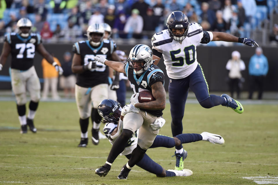 Carolina Panthers wide receiver D.J. Moore (12) runs the ball while Seattle Seahawks outside linebacker K.J. Wright (50) and cornerback Tre Flowers (21) chase during the second half of an NFL football game in Charlotte, N.C., Sunday, Dec. 15, 2019. (AP Photo/Mike McCarn)