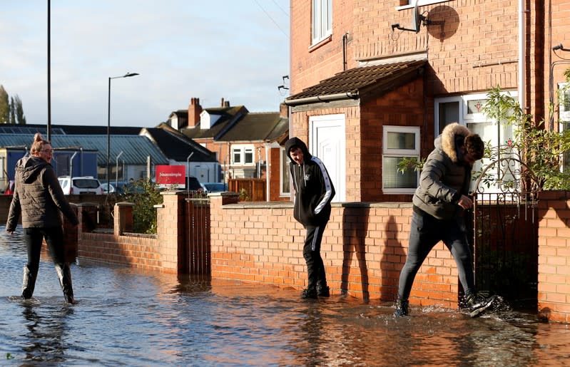 Residents walk though a flooded street in Bentley, north of Doncaster