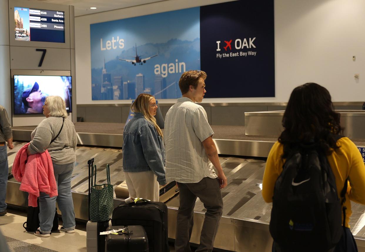 image of people standing around baggage claim at airport