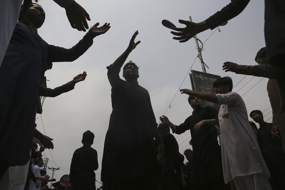 Shiite Muslims beat their chest in a ritual during a Muharram procession, in Peshawar, Pakistan, Monday, Aug. 8, 2022. Muharram, the first month of the Islamic calendar, is a month of mourning for Shiites in remembrance of the death of Hussein, the grandson of the Prophet Muhammad, at the Battle of Karbala in present-day Iraq in the 7th century. (AP Photo/Muhammad Sajjad)