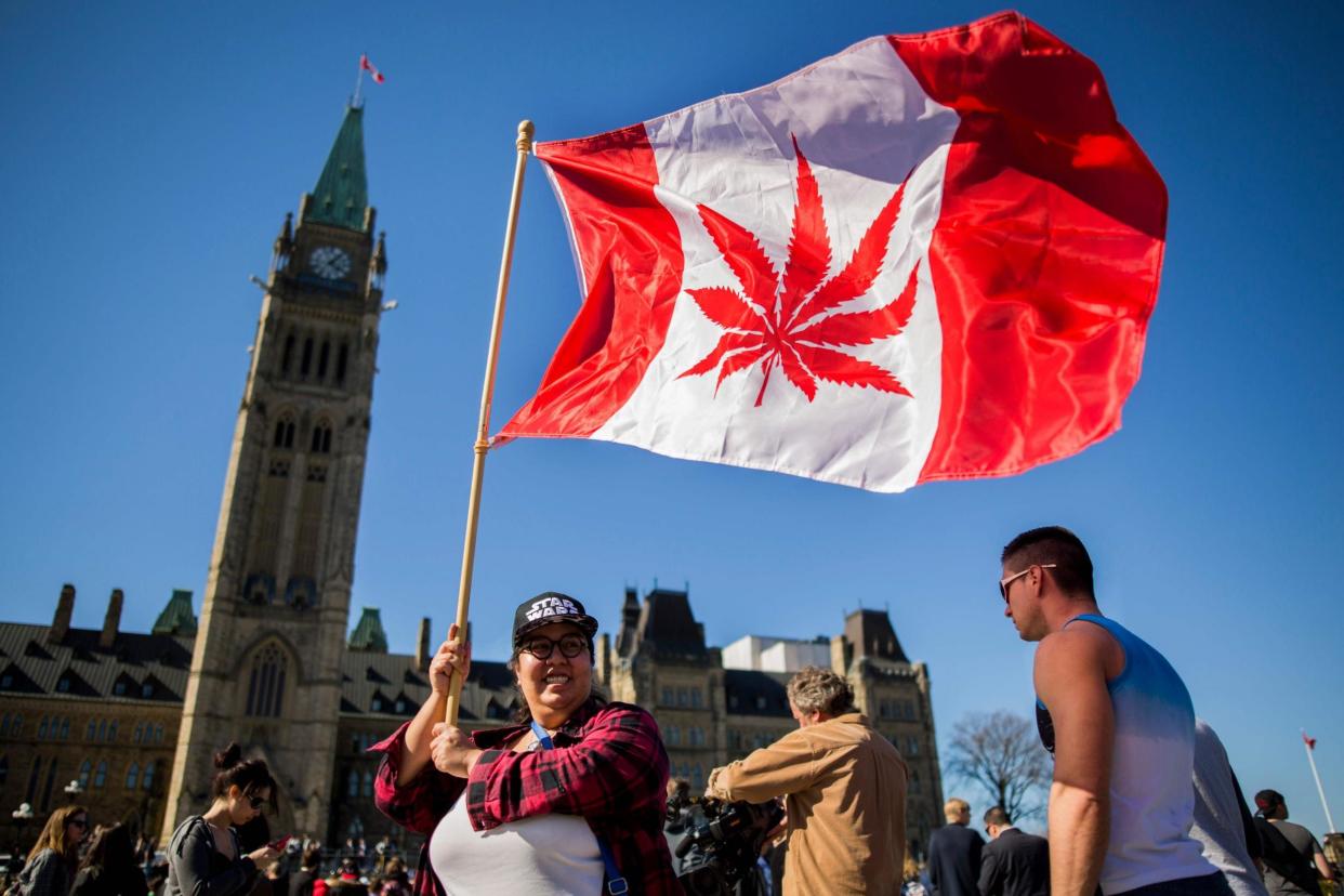 A woman waves a flag with a marijuana leaf on it as crowds gather to celebrate National Marijuana Day in Canada (file image): AFP/Getty Images