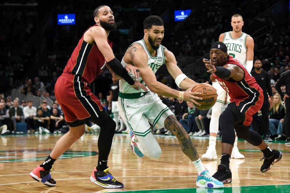 Celtics forward Jayson Tatum (0) drives to the basket between Miami defenders Caleb Martin (16) and Bam Adebayo (13) during the Sunday's game in the first round for the 2024 NBA playoffs at TD Garden.