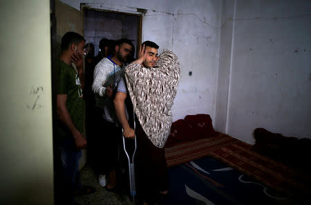 Palestinian cyclist Alaa Al-Daly, 21, who lost his leg by a bullet fired by Israeli troops, is welcomed by his mother at his house in Rafah, southern Gaza Strip, April 18, 2018. REUTERS/Suhaib Salem