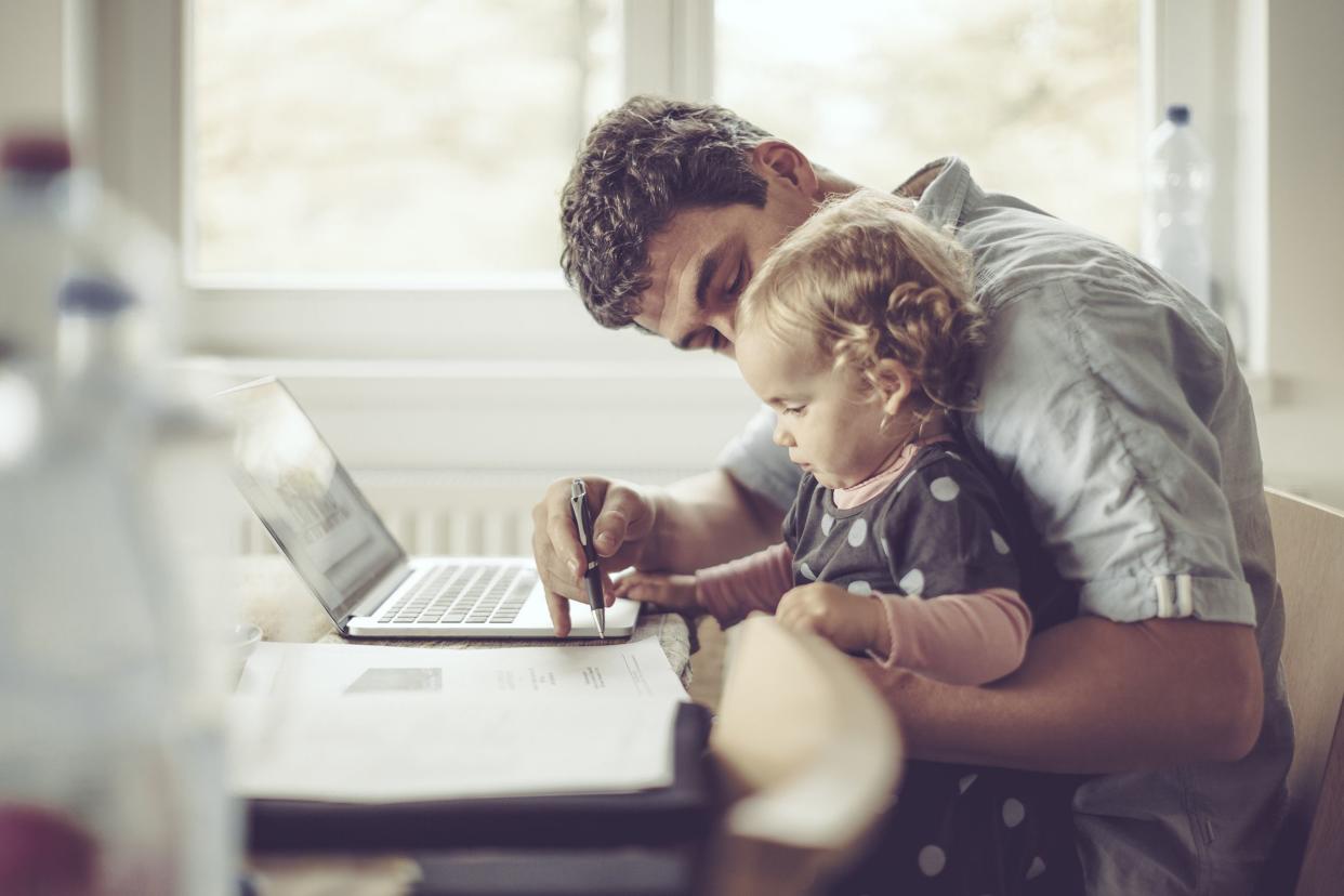 father is showing his daughter things on a laptop