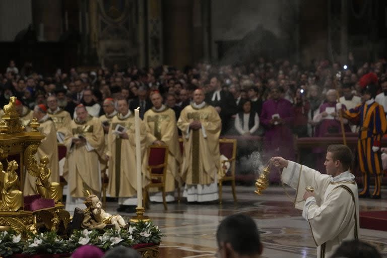 Un sacerdote rocía incienso frente a una estatua del Niño Jesús mientras el Papa Francisco preside la misa de Nochebuena, en la Basílica de San Pedro en el Vaticano, el domingo 24 de diciembre de 2023