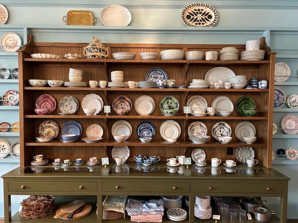 A cabinet full of dinnerware and glassware sit uniformly at Oakstreet Shoppe on Friday, April 19, 2024. The retail store offers a variety of home essentials to purchase.