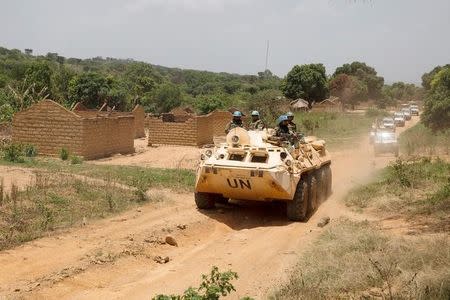 FILE PHOTO: United Nations peacekeeping force vehicles drive by houses destroyed by violence in September, in the abandoned village of Yade, Central African Republic April 27, 2017. REUTERS/Baz Ratner