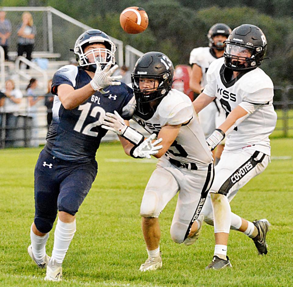 Great Plains Lutheran's Thomas Erickson (12) makes a juggling catch against Waverly-South Shore defenders Cody Thompson and Colton Kranz (right) during their high school football game Friday night at Watertown Stadium. GPL won 31-22.